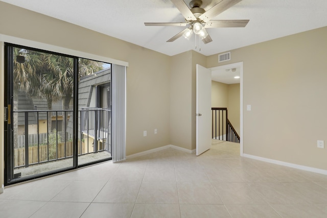 spare room with ceiling fan and light tile patterned floors