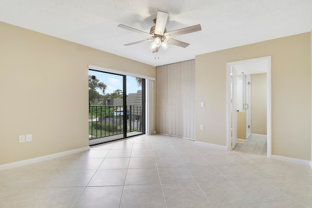 tiled empty room featuring a textured ceiling and ceiling fan