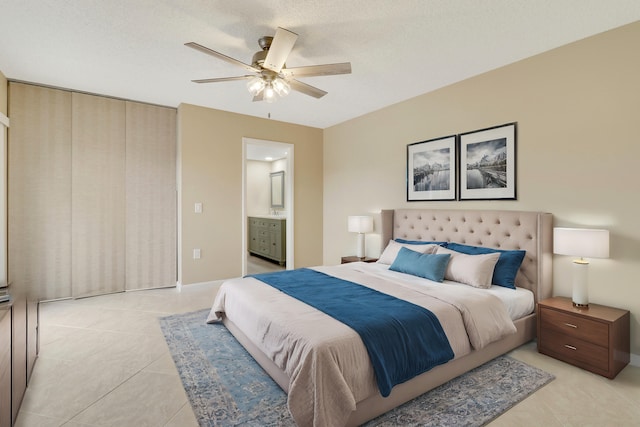 tiled bedroom featuring ensuite bath, a textured ceiling, and ceiling fan