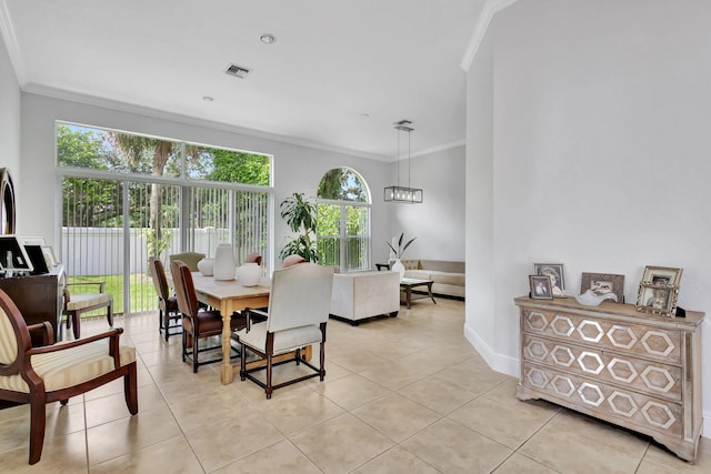 dining space featuring a notable chandelier, light tile patterned floors, and crown molding