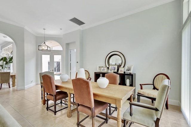 dining room with an inviting chandelier, light tile patterned flooring, and crown molding