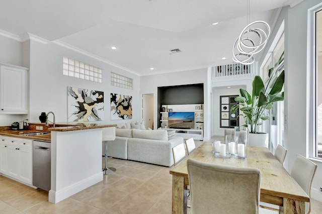 dining space featuring sink, light tile patterned floors, and crown molding