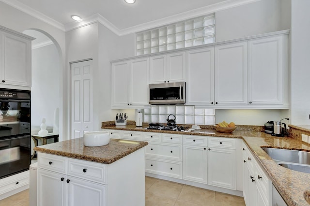 kitchen with white cabinets, stainless steel appliances, and light stone counters