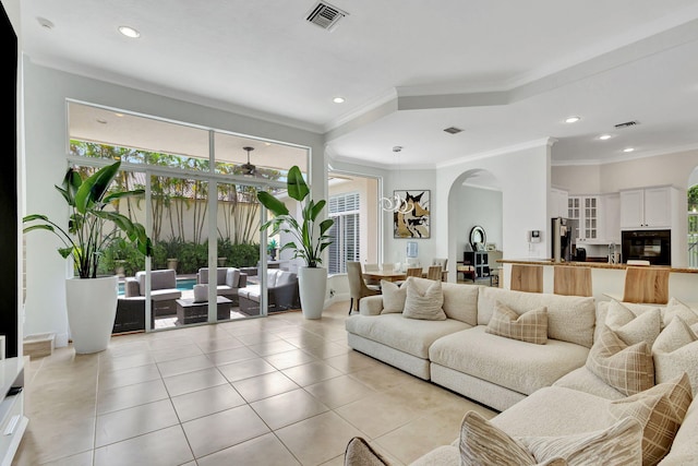 living room with light tile patterned flooring and crown molding