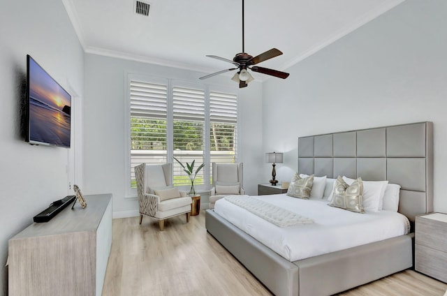 bedroom with light hardwood / wood-style floors, ceiling fan, and crown molding