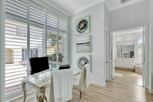 office with a wealth of natural light, crown molding, and light hardwood / wood-style flooring