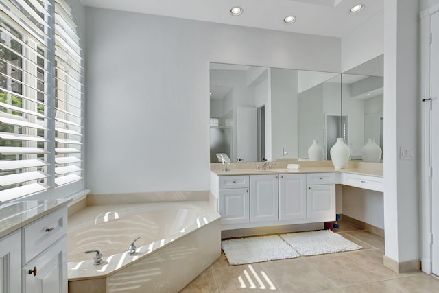 bathroom featuring a tub to relax in, vanity, and tile patterned flooring