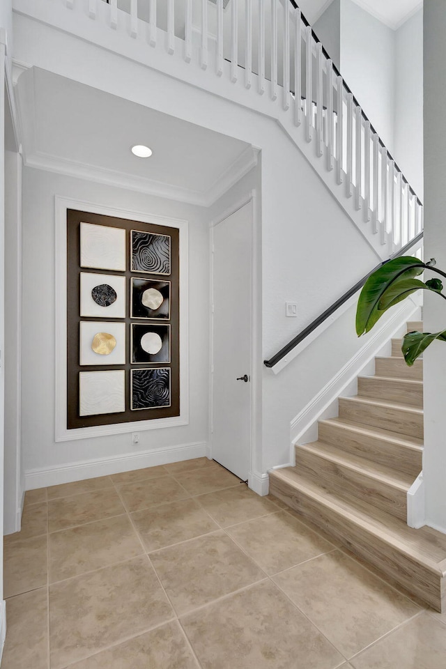 staircase with tile patterned flooring and ornamental molding