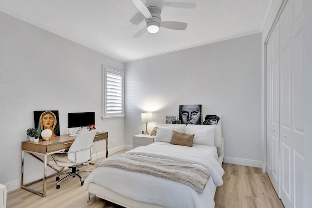 bedroom featuring ornamental molding, a closet, light wood-type flooring, and ceiling fan