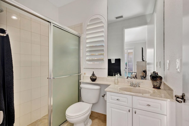 bathroom with toilet, vanity, tile patterned flooring, and a shower with shower door