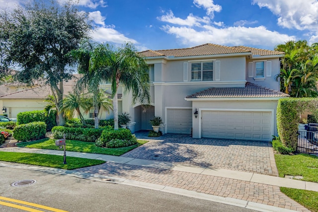 mediterranean / spanish home with a front lawn and a garage