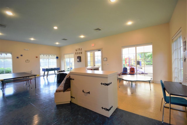 kitchen featuring white cabinets, a wealth of natural light, and an island with sink