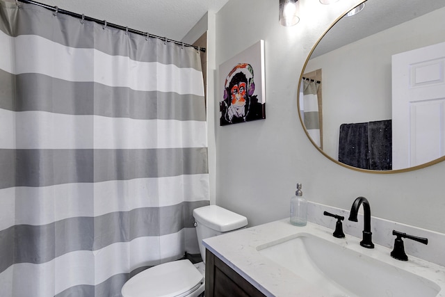 bathroom featuring toilet, vanity, and a textured ceiling