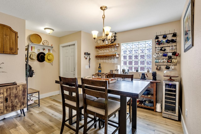 dining room with a textured ceiling, hardwood / wood-style flooring, and a chandelier