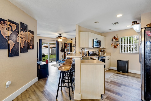 kitchen featuring stainless steel appliances, sink, and light wood-type flooring