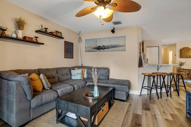 living room featuring light hardwood / wood-style floors and ceiling fan