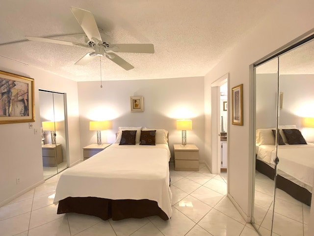 bedroom featuring ceiling fan, light tile patterned floors, and a textured ceiling