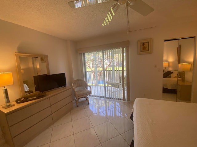 tiled bedroom featuring access to exterior, a textured ceiling, a closet, and ceiling fan