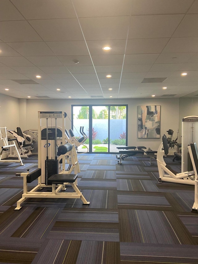 workout area with carpet flooring and a paneled ceiling