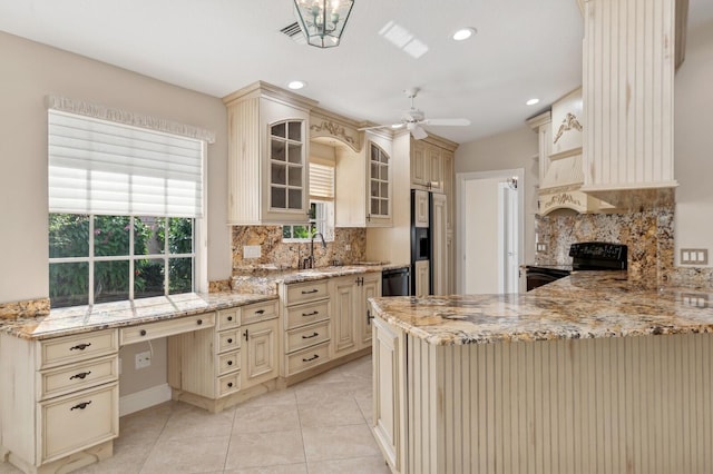 kitchen with ceiling fan, black appliances, light stone counters, and cream cabinetry