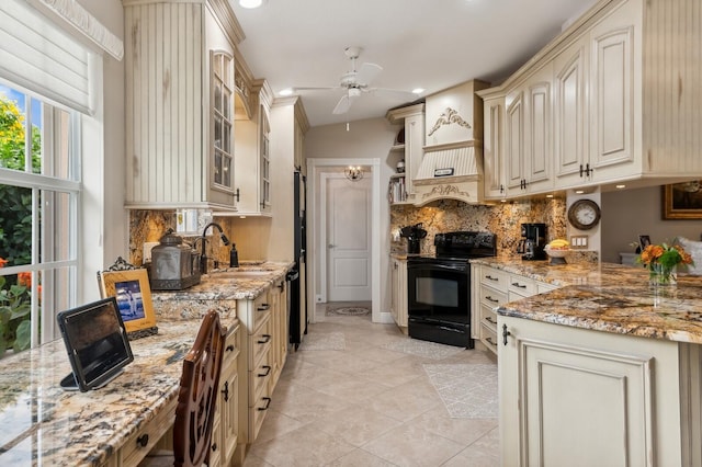 kitchen with ceiling fan, sink, black range with electric cooktop, light stone counters, and cream cabinetry