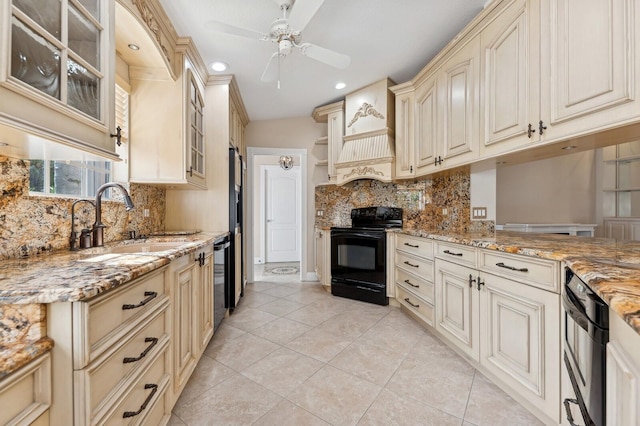 kitchen with backsplash, cream cabinets, black appliances, sink, and light stone counters