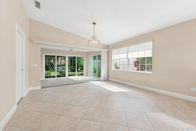 unfurnished room with ceiling fan with notable chandelier, light tile patterned floors, and vaulted ceiling