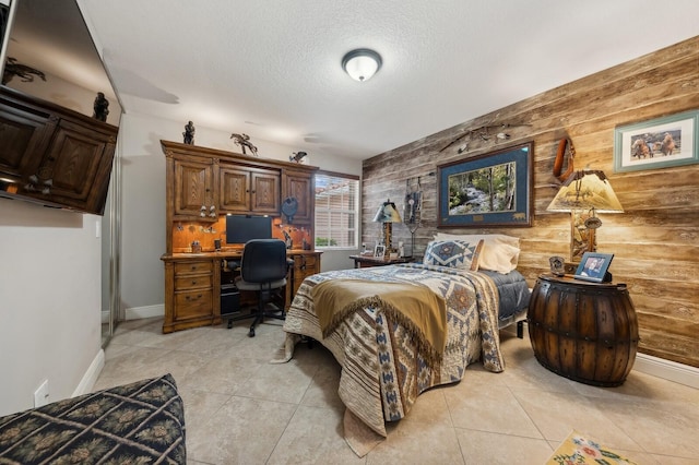 tiled bedroom featuring a textured ceiling and wooden walls