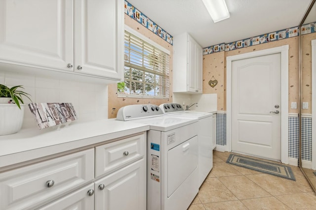 laundry room featuring cabinets, independent washer and dryer, and light tile patterned floors