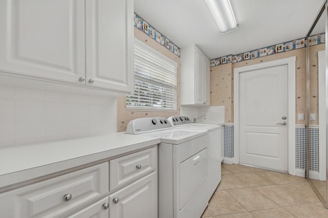 washroom with cabinets, light tile patterned floors, and washing machine and dryer