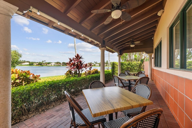 view of patio with a water view and ceiling fan