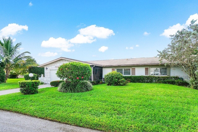 ranch-style home featuring a front lawn and a garage