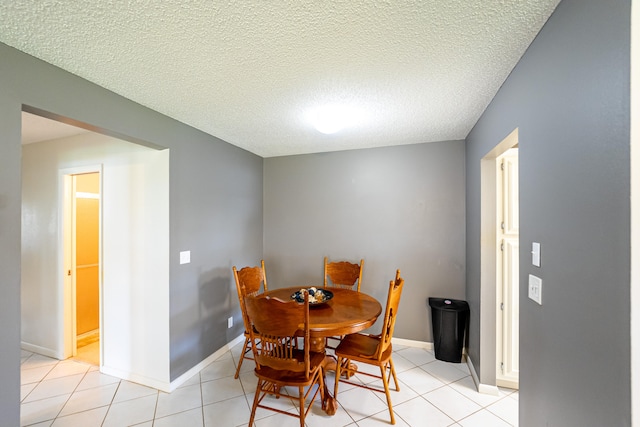 dining room with a textured ceiling and light tile patterned floors