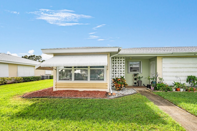 view of front of property with cooling unit and a front yard