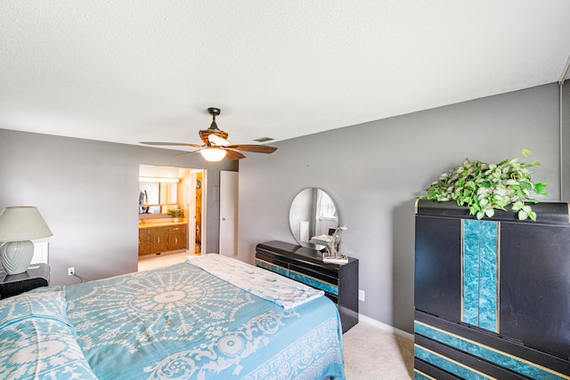 carpeted bedroom with a textured ceiling, ensuite bath, and ceiling fan