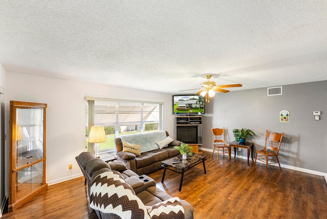 living room featuring wood-type flooring, ceiling fan, and a textured ceiling