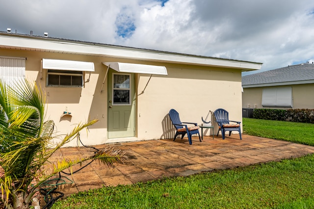 back of house with a patio and a lawn