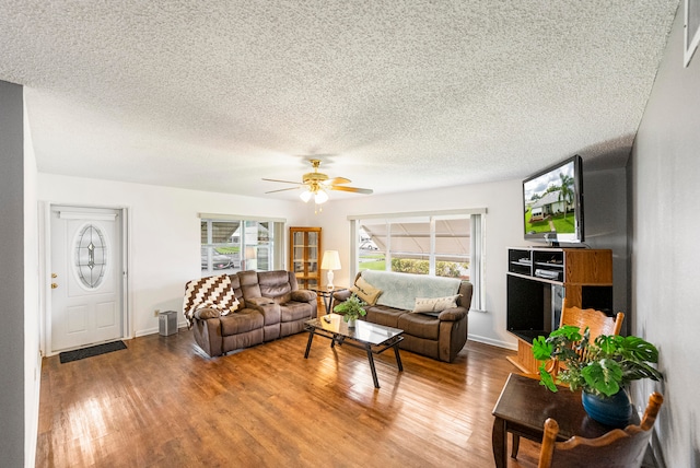 living room with a textured ceiling, hardwood / wood-style flooring, and ceiling fan