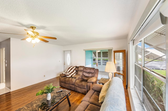 living room with a textured ceiling, hardwood / wood-style flooring, and ceiling fan