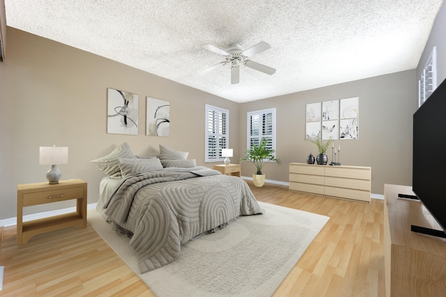 bedroom featuring ceiling fan, hardwood / wood-style floors, and a textured ceiling