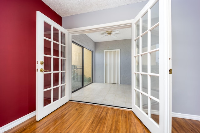 unfurnished sunroom with ceiling fan and french doors