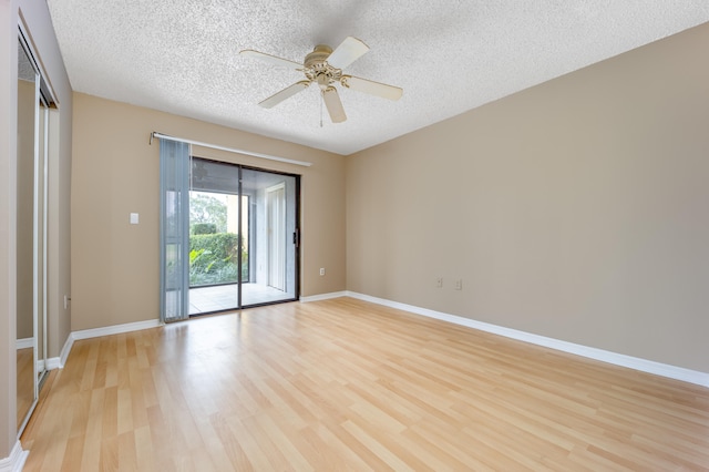 empty room with ceiling fan, light hardwood / wood-style floors, and a textured ceiling