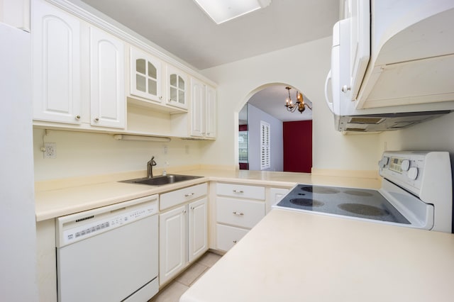 kitchen featuring white appliances, white cabinets, sink, kitchen peninsula, and a chandelier