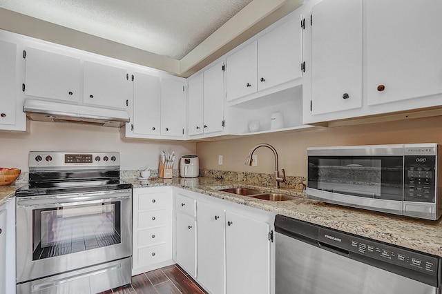 kitchen featuring under cabinet range hood, stainless steel appliances, a sink, white cabinets, and wood tiled floor