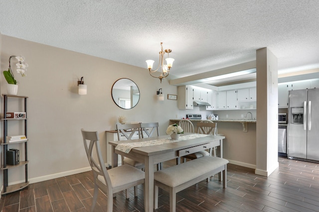 dining room featuring a textured ceiling, a notable chandelier, and dark hardwood / wood-style floors