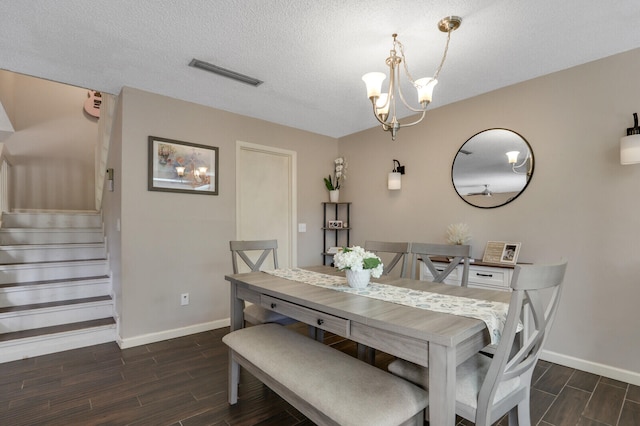 dining space with wood tiled floor, visible vents, a notable chandelier, and stairs