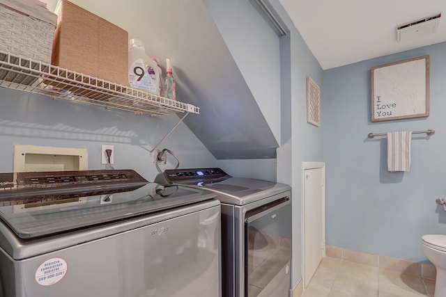 laundry room with light tile patterned floors and washer and clothes dryer