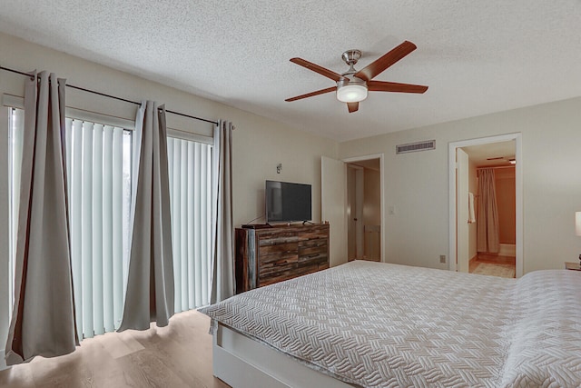 bedroom featuring a ceiling fan, visible vents, and a textured ceiling