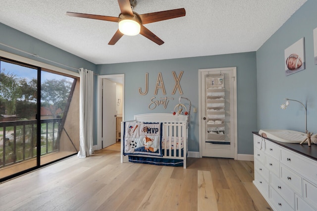 bedroom featuring access to outside, light hardwood / wood-style floors, a textured ceiling, and ceiling fan