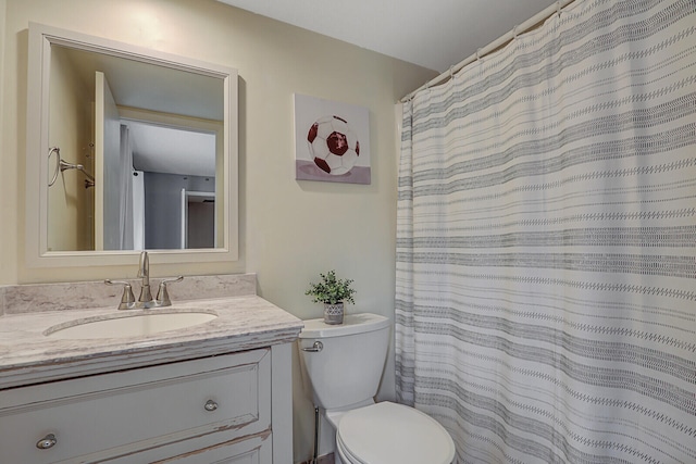 bathroom with toilet, a shower with shower curtain, and vanity